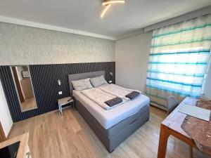 a small bedroom with a bed and a table at Pension Günther self Check-in free parking in Graz
