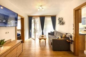 a living room with a couch and a tv at Haus am Lift in Kleinarl