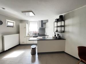 a kitchen with a counter and a refrigerator at Moderne und gemütliche Wohnung in Herzogenrath +5 photos