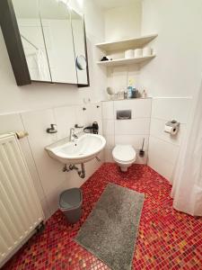 a white bathroom with a sink and a toilet at Moderne und gemütliche Wohnung in Herzogenrath
