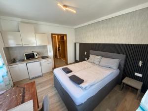 a bedroom with a large bed and a kitchen at Pension Günther self Check-in free parking in Graz