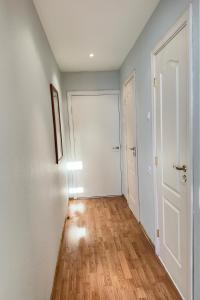 an empty hallway with white walls and wood floors at Cozy 32 in Preiļi