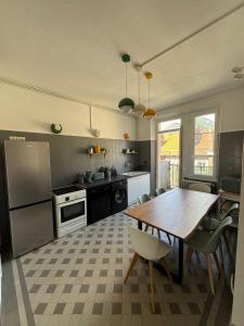 a kitchen with a wooden table and chairs in it at Avocado - Garage inclus - T3 - 96m2 - lumineux - Centre ville tout à pied in Grenoble