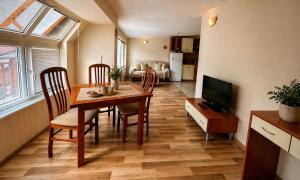a living room with a dining room table and a television at Panoramic Cozy Apartment in Beli Iskar