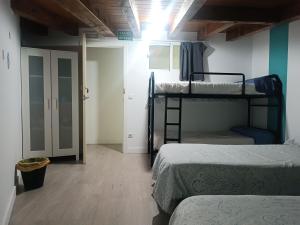 a room with two bunk beds and a hallway at Albergue Casa Txakainlo in Lesaka