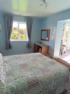 a bedroom with a bed and a window at West Point B&B in Bude
