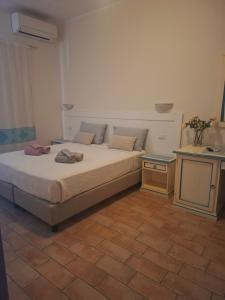 a bedroom with a large bed and a table at B&B La Pavoncella in San Teodoro