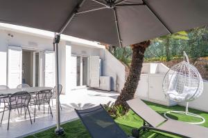 a patio with a table and chairs and an umbrella at La Casetta di Carol in Capri