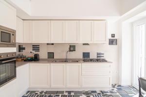 a kitchen with white cabinets and a sink at La Casetta di Carol in Capri