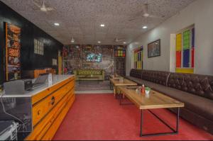 a waiting room with couches and tables in a restaurant at Zero Amer Royal Farm Stay in Jaipur