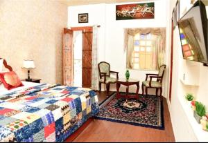 a bedroom with a bed and two chairs and a table at Zero Amer Royal Farm Stay in Jaipur +3 photos