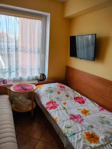 a bedroom with a bed with a flower blanket on it at Pokój 2-osobowy in Węgorzewo