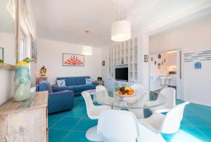 a living room with a blue couch and a table and chairs at Relais Miramar in Termini