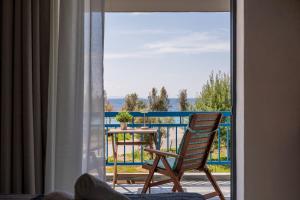 a room with a chair and a table on a balcony at Orion 2 in Neos Marmaras