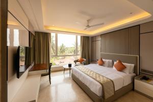 a bedroom with a large bed and a large window at Fortune Plaza Hotel in Udupi