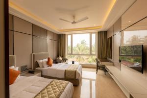 a hotel room with two beds and a large window at Fortune Plaza Hotel in Udupi