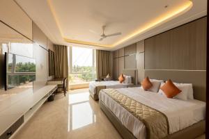 a hotel room with two beds and a large window at Fortune Plaza Hotel in Udupi