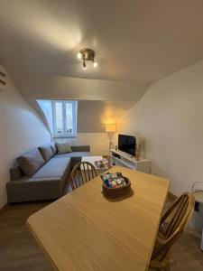 a living room with a table and a couch at Le Petit Ussellois in Ussel