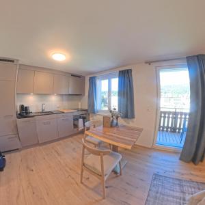 a kitchen and dining room with a table and chairs at Stylish Aurora Studio with Mountain Views Lenzerheide in Lenzerheide +9 photos