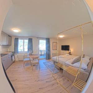 a bedroom with a bed and a kitchen with a table at Stylish Aurora Studio with Mountain Views Lenzerheide in Lenzerheide