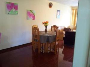 tavolo da pranzo con sedie e vaso di fiori di Kammal Villa a Flic-en-Flac