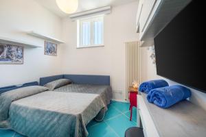 a bedroom with two beds and a flat screen tv at Relais Miramar in Termini
