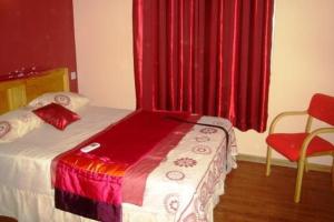フリック・アン・フラックにあるKammal Villaのベッドルーム1室(ベッド1台付)、赤いカーテン付きの窓が備わります。