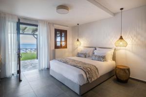 a bedroom with a bed with a view of the ocean at Tilia Resort in Mouresi +213 photos