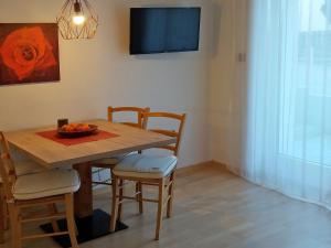 uma mesa de jantar com cadeiras e uma televisão em Appartements Erika em Falzes