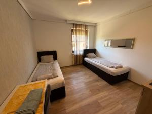 a room with two beds and a table in it at Pension Günther self Check-in free parking in Graz +18 photos