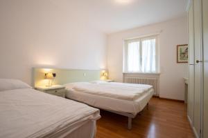 a bedroom with two beds and a window at Castel View Apartment - Gardaslowemotion in Tenno