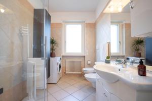 a bathroom with a sink and a toilet at Castel View Apartment - Gardaslowemotion in Tenno