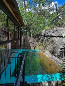 a pool of water next to a building at The Glenrock Wellness Nature Resort in Belihuloya