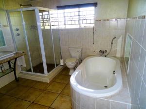 a bathroom with a tub and a toilet and a shower at Jimmy's Place in Dinokeng Game Reserve +70 photos
