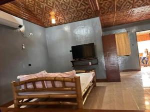 a bedroom with a bed and a flat screen tv at Gratum Beach Resort in Dapitan