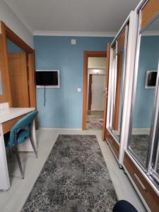 a room with a blue wall and a table and a television at Can Residence in Trabzon