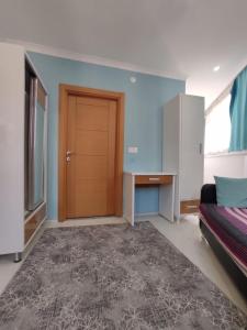 a room with a door and a bed and a desk at Can Residence in Trabzon