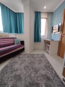 a room with a couch and a desk and a television at Can Residence in Trabzon