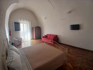a bedroom with a bed and a red chair at Tursi Relais Virtus in Tursi