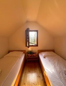 two beds in a small room with a window at Mežnarija - Cerovec in Dolenjske Toplice +6 photos