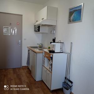 a small kitchen with a sink and a refrigerator at résidence la citadelle in Saint-Florent