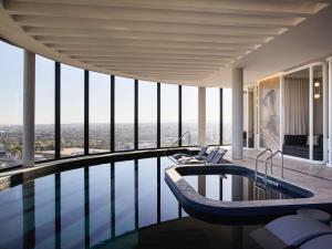a swimming pool with a tub in a building at Hotel Chadstone Melbourne MGallery Collection in Chadstone