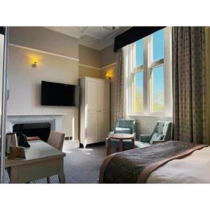 Ein Hotelzimmer mit Schlafzimmer, Bett und Kamin in der Unterkunft Wroxall Abbey Hotel & Estate in Wroxall
