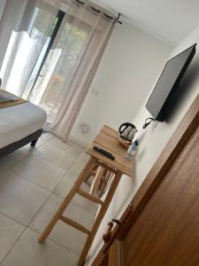 a room with a table with a television on a wall at Chambres d’hôtes Casarena in Porto-Vecchio