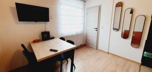 a room with a table with chairs and a television at Apartments and Rooms Milena in Kranjska Gora