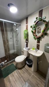 a bathroom with a toilet and a sink and a shower at Hospedaje in Salento