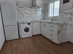 a kitchen with a washer and dryer in it at El Zamora in Sanlúcar de Barrameda