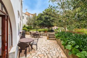 a patio with tables and chairs and plants at Casas da Biquinha in Sintra