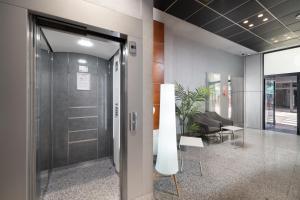 an office lobby with a glass door and a chair at Hotel Longoria Plaza by Pandora Hoteles in Oviedo