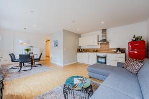 ein Wohnzimmer mit Sofa und Tisch und eine Küche in der Unterkunft Elflein Quartier in Potsdam